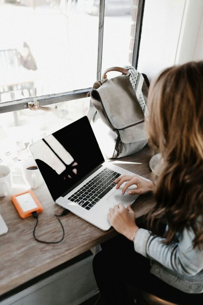 a woman using a laptop to study technical vocabulary on a coffee shop