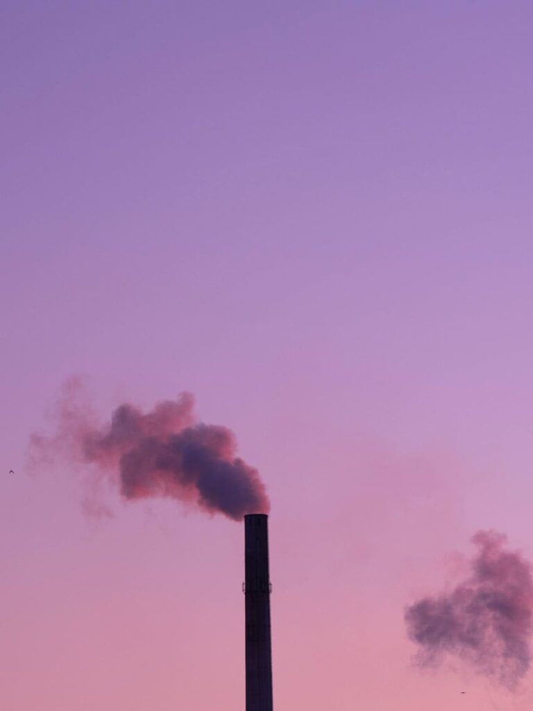 a-factory-chimney-belching-smoke-into-the-violet-sky