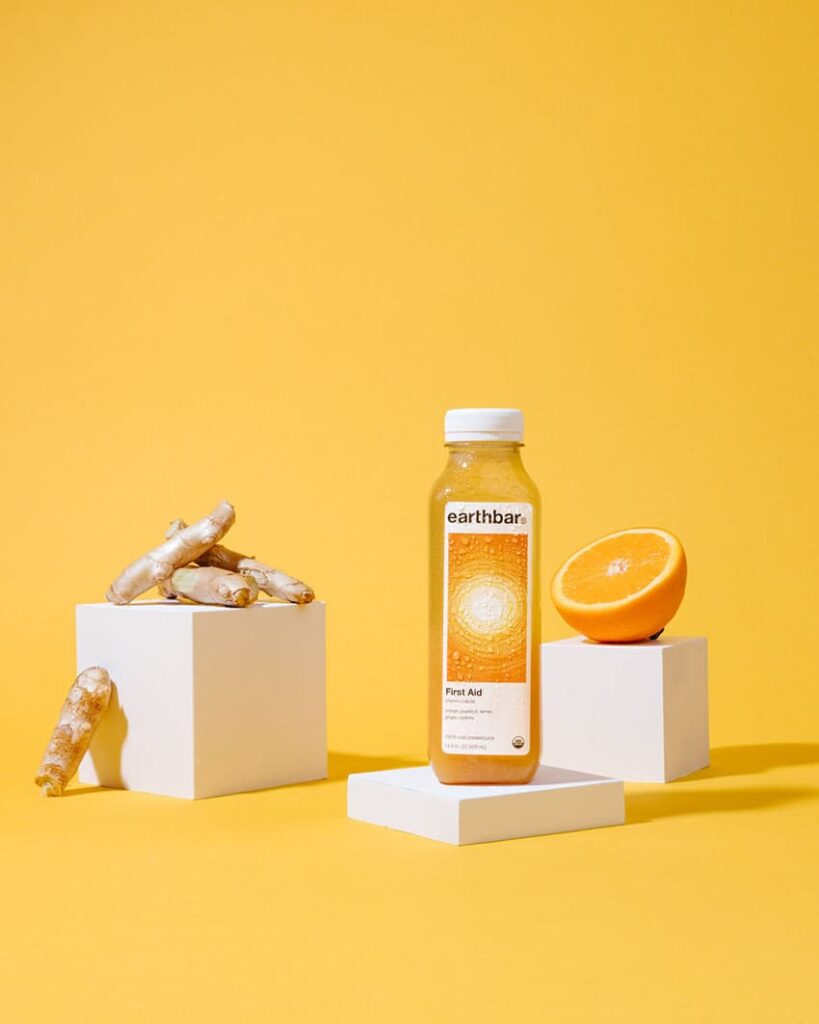 product photography featuring a citric skin tonic, with oranges and ginger roots
