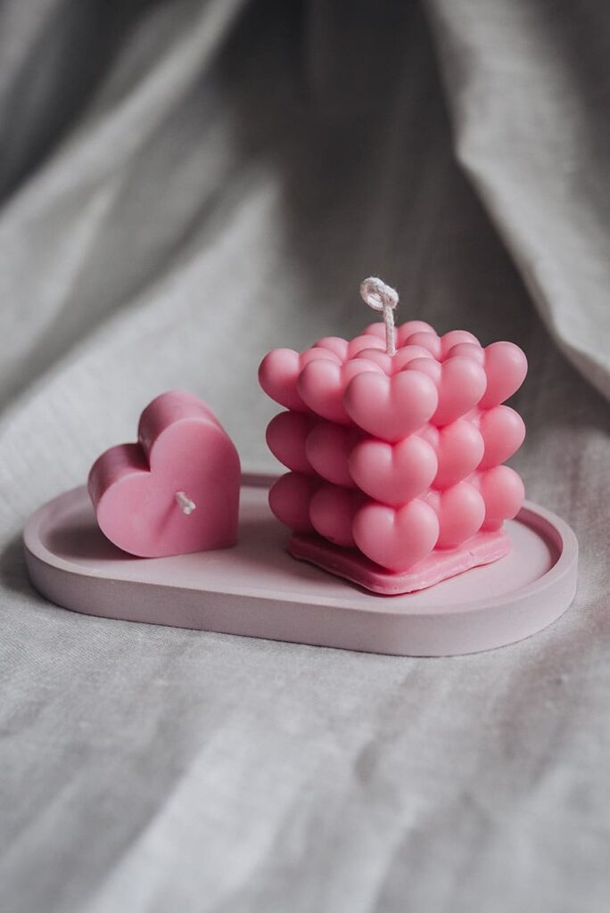 a pink bubble candle and a pink small heart candle