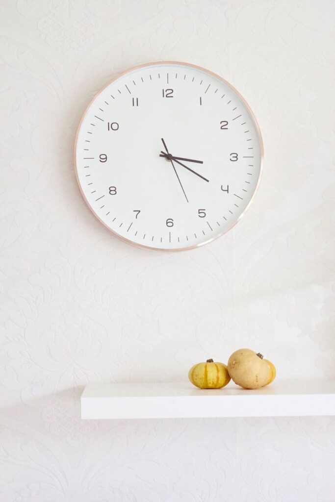 a minimalist clock hung over a white wall