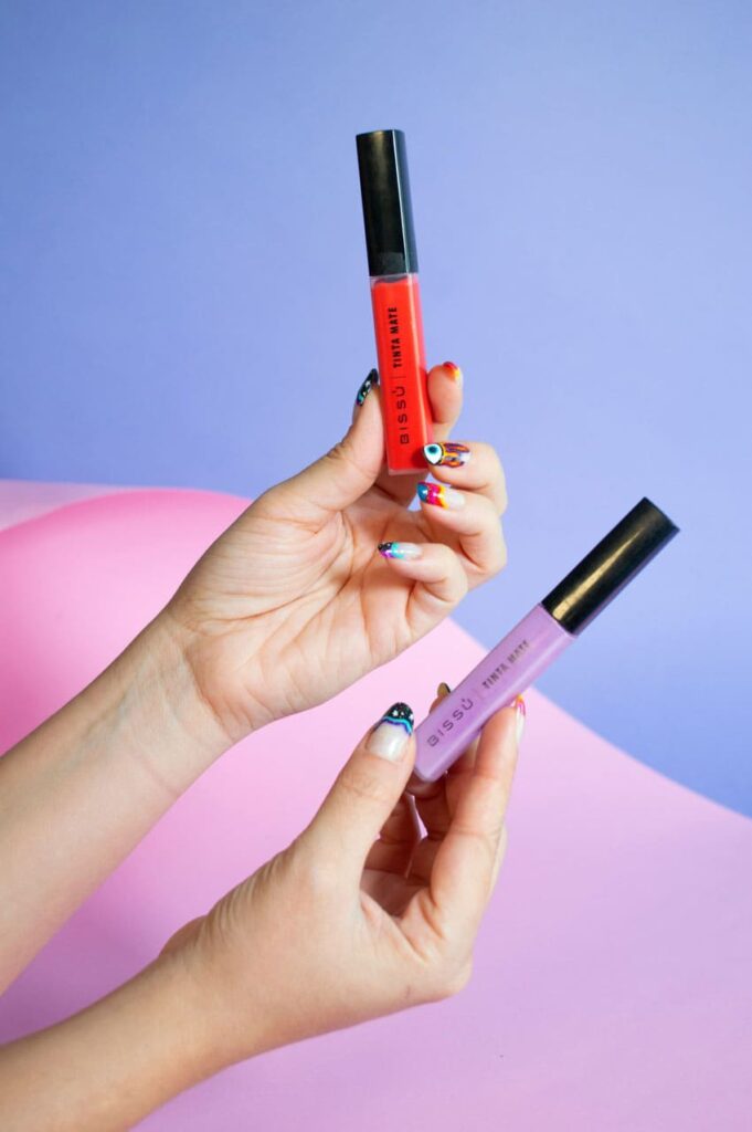 a woman holding two lipsticks