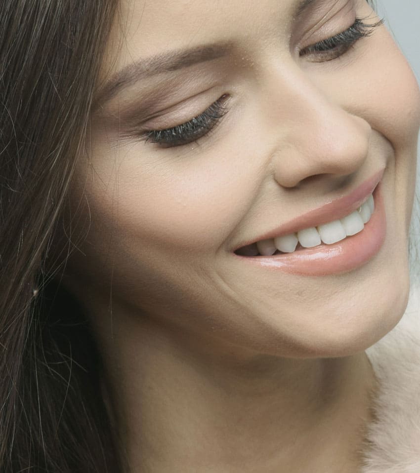 a brunette girl showing her white teeth
