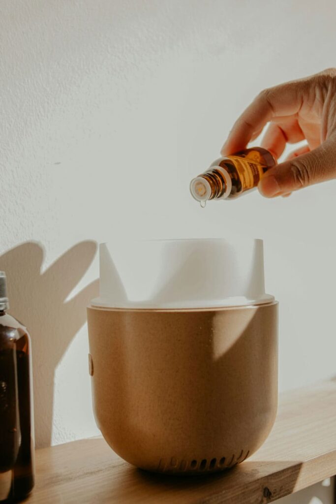a woman's hand putting essential oil on mist diffuser aromatherapist as one of the best beauty side hustles