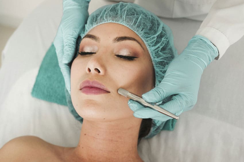 a dermatlogist performing a treatment on another woman's face