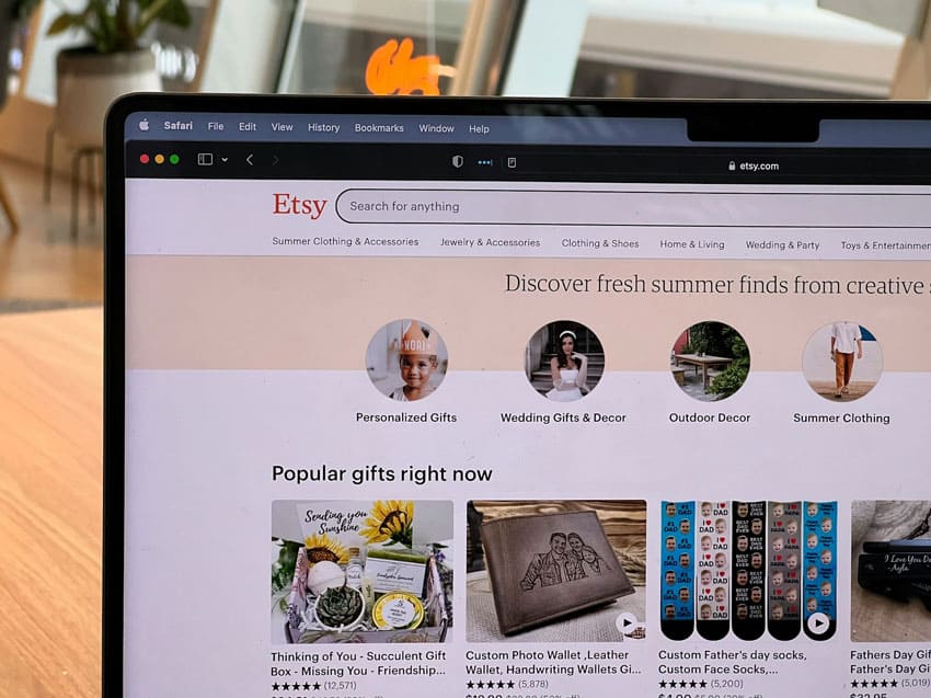 a laptop showing Etsy's home page