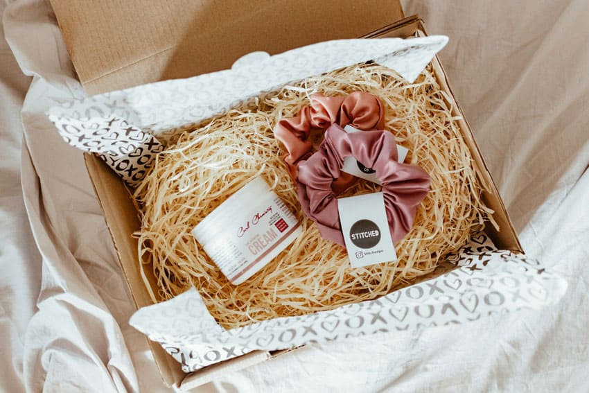 a subscription box containing a scrunchie and skincare products