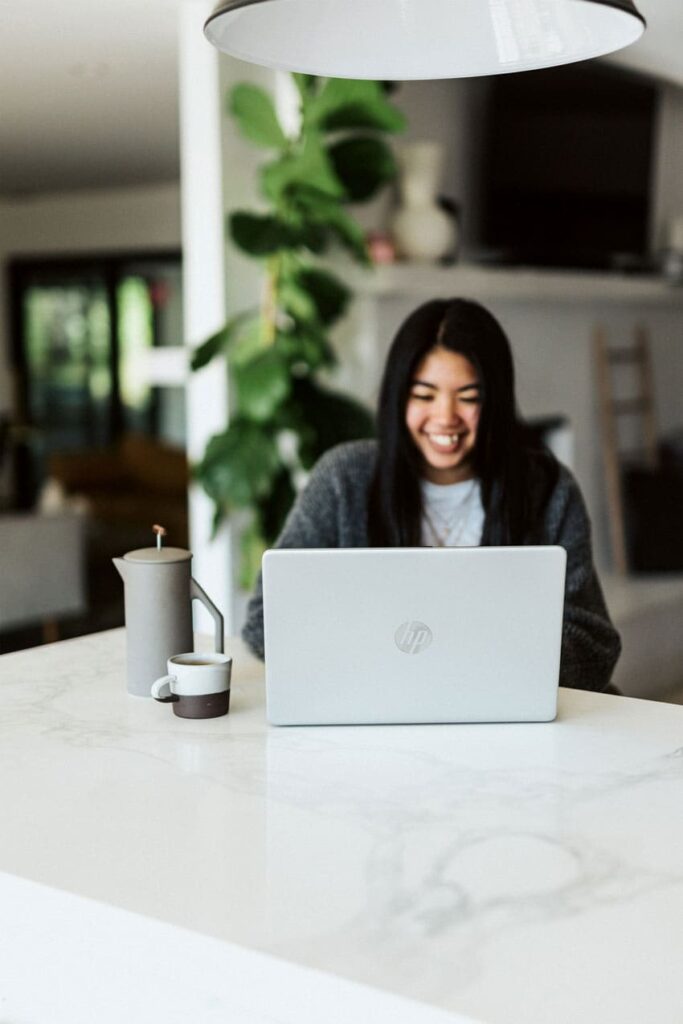 a woman talking happily with her client through a video call