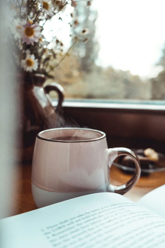 a book and a steaming cup of coffee