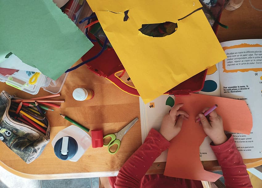 a girl doing crafts for kids with papeer