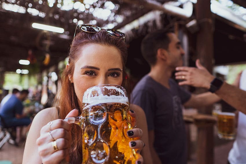 a woman drinkin beer in an oktoberfest setting