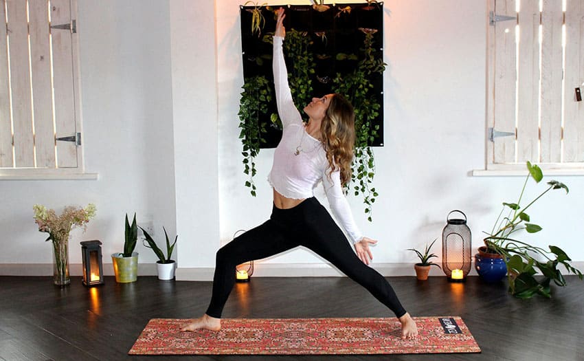 a young woman doing yoga at home cozy setting with candles