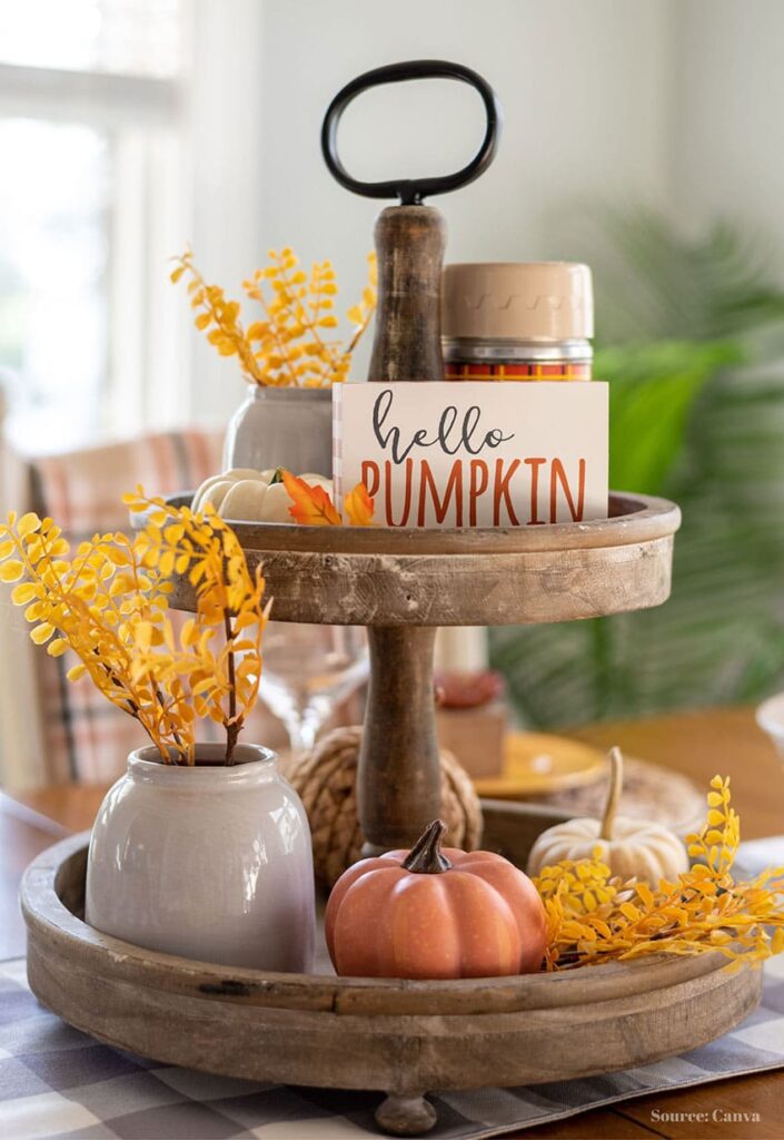 a tiered wooden tray containing yellow florals in ceramic vases, decorative pumpkins and a hello pumpkin fall sign