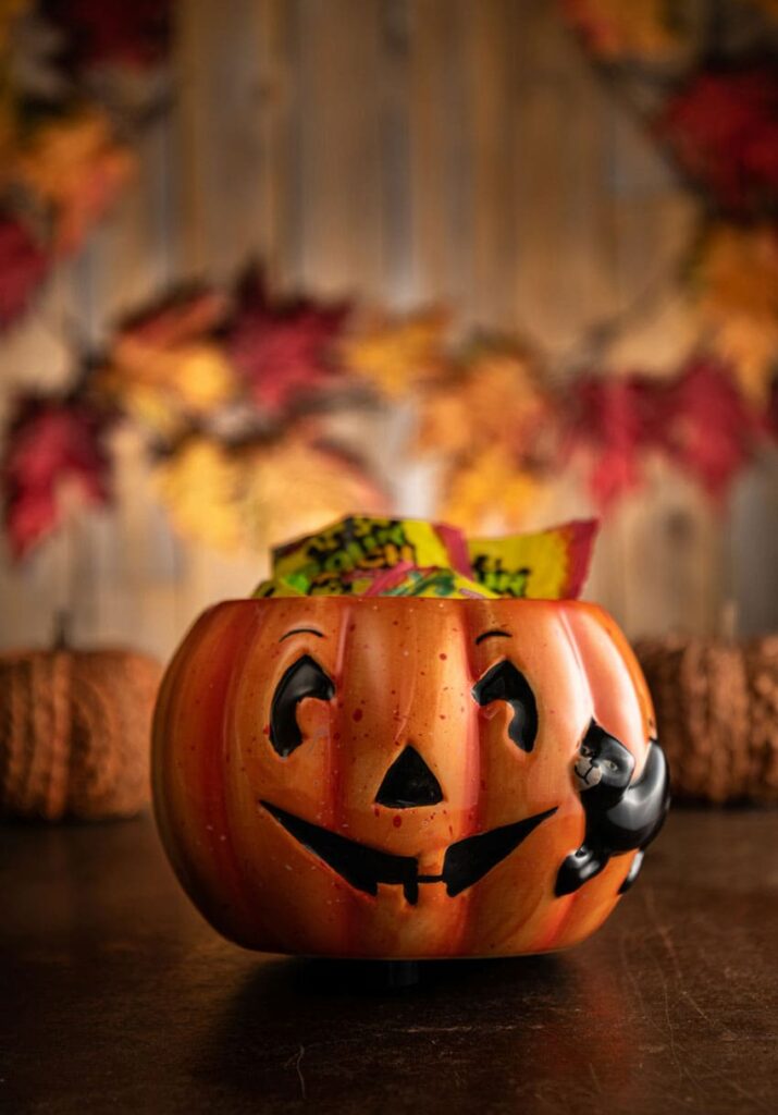 a pot shaped as a jack o' lantern with a cat