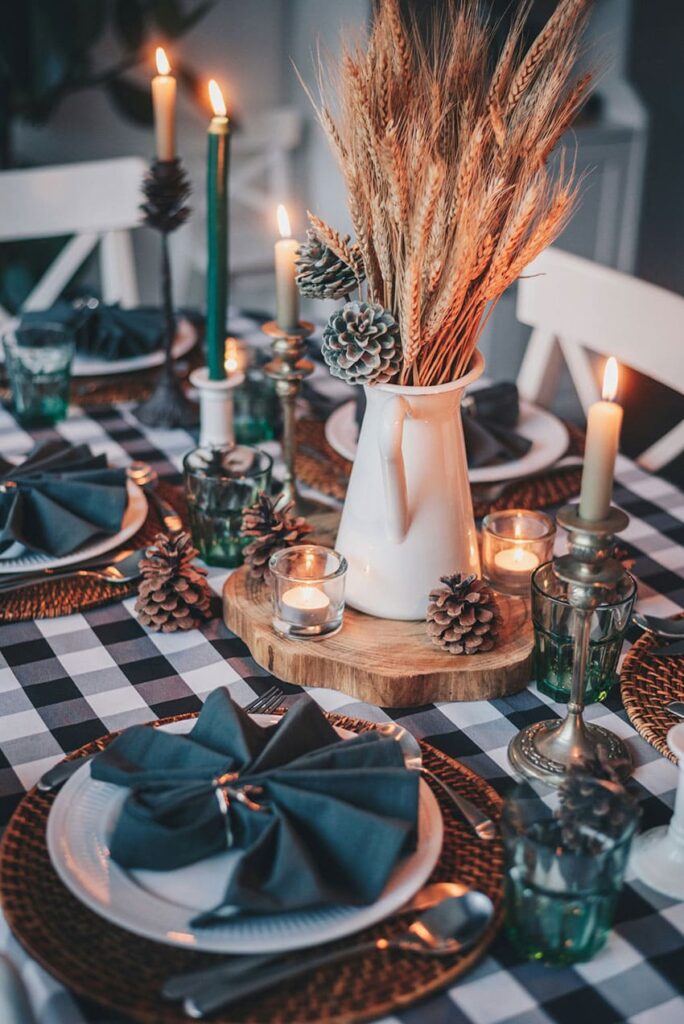 a kitchen table decorated with blue colors, dry flower centerpiece and several candles blue and red table runner