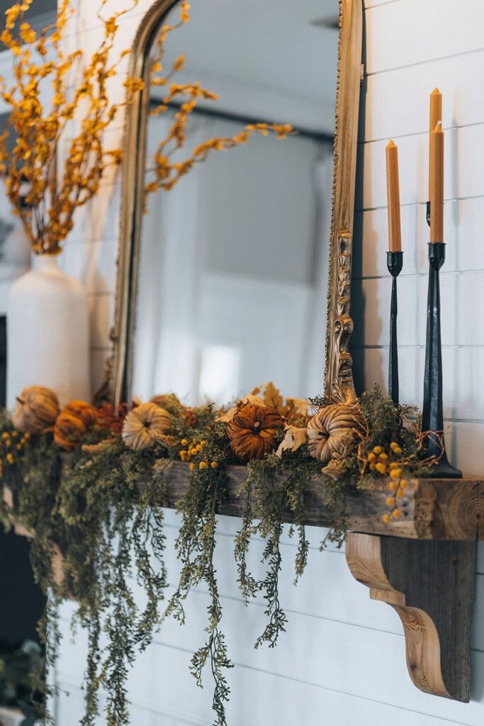 a garland made out of natural items like dried plants and a bown pumpkin