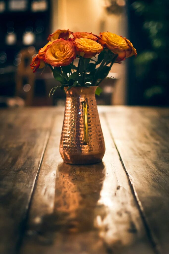 a vintae vase with orange flower bouquet inside